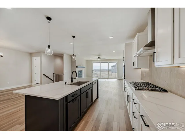 a kitchen with granite countertop a sink stove and cabinets