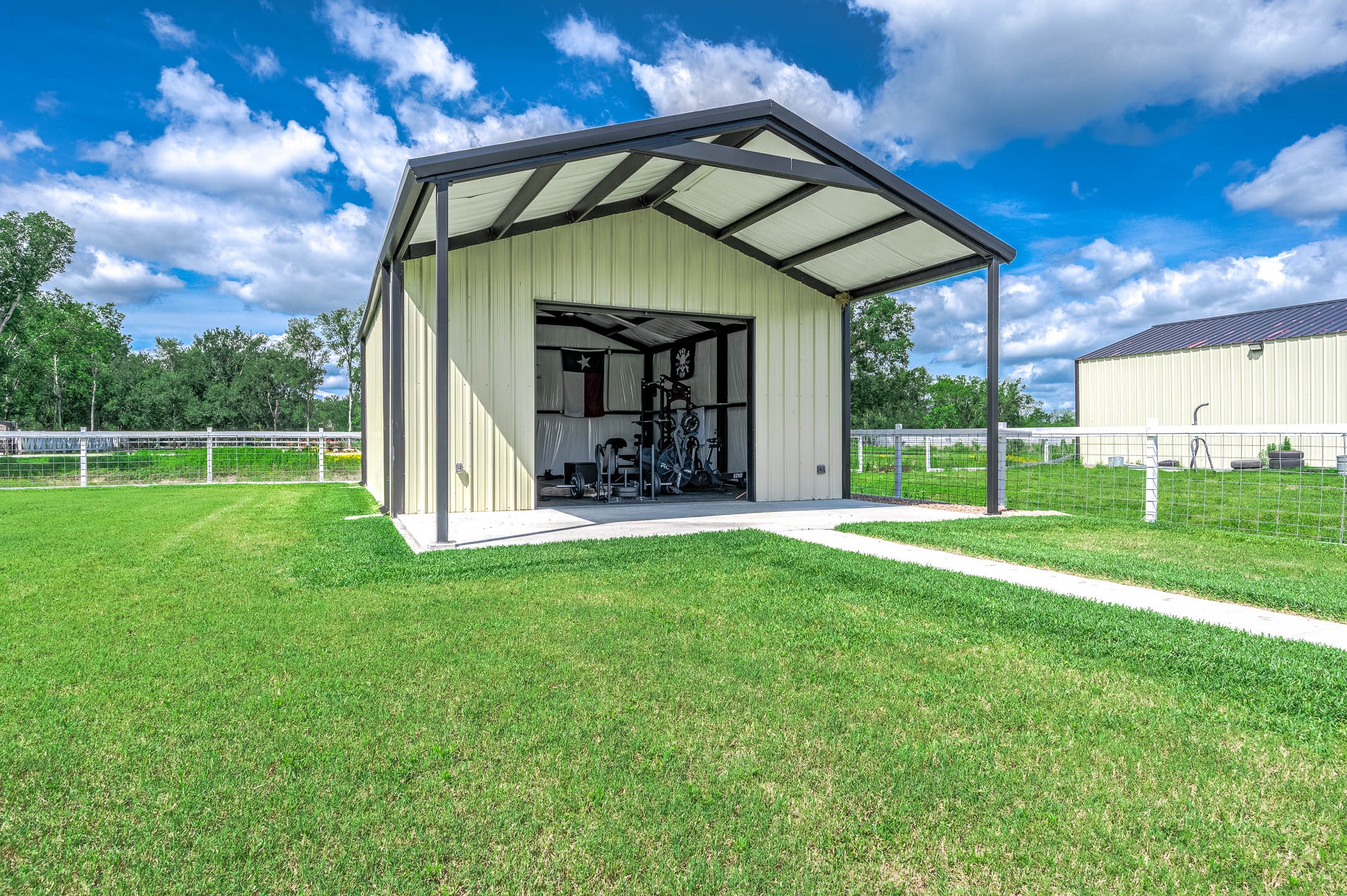 8032 Short Road Needville, TX 77461 - Photo 34 of 50 Another view of the versatile barn-style building highlights the spacious setup and flexibility this additional structure offers. Currently utilized as a private gym, the space can easily adapt to a variety of uses including storage, hobbies, recreation, or workshop space.