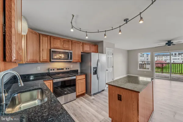 a kitchen with granite countertop a sink stainless steel appliances and cabinets