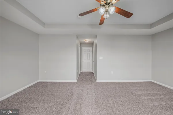 an empty room with closet and a chandelier fan