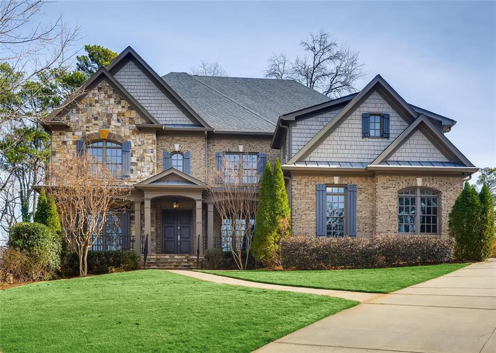 Elegant brick and stone home with beautifully manicured lawn.