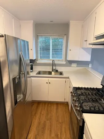a kitchen with a sink a refrigerator and window