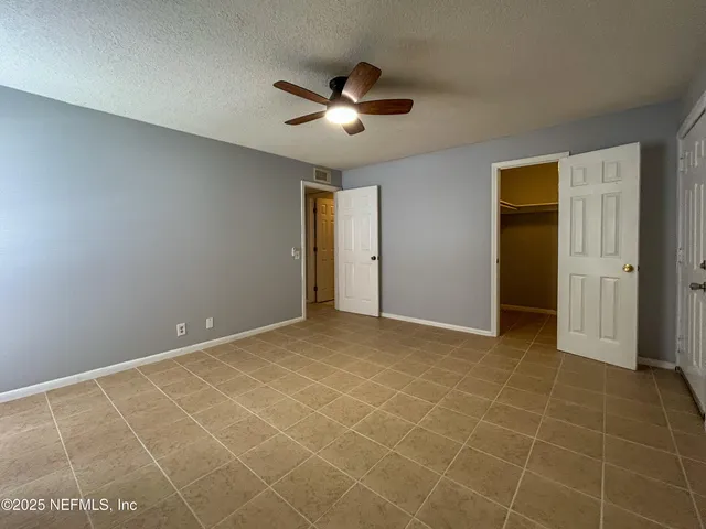 a view of an empty room with a ceiling fan