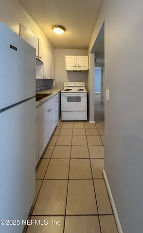 a kitchen with a sink a refrigerator and cabinets