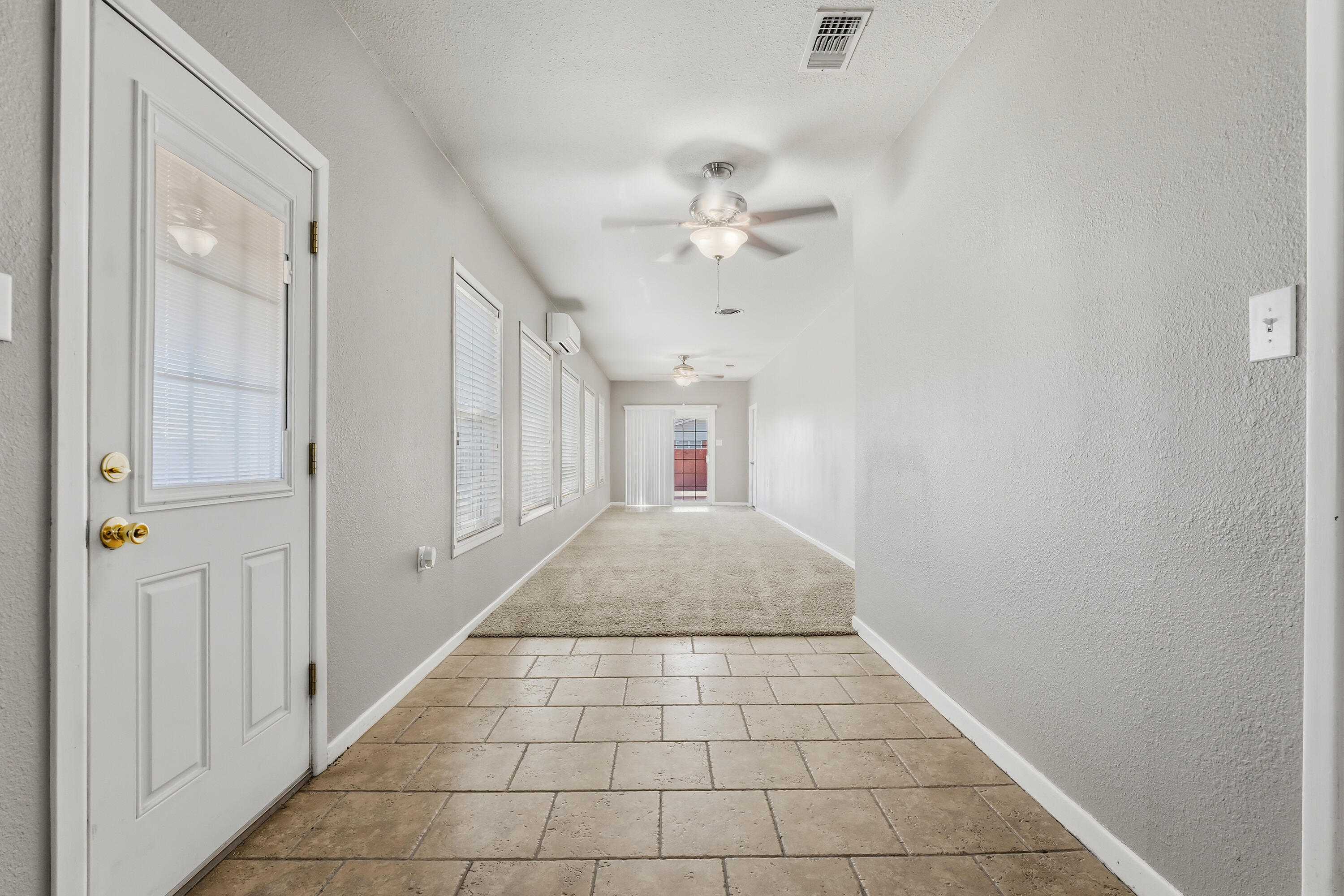 4831 10th Street Lubbock, TX 79416 - Photo 17 of 25 a view of hallway with a window and a ceiling fan