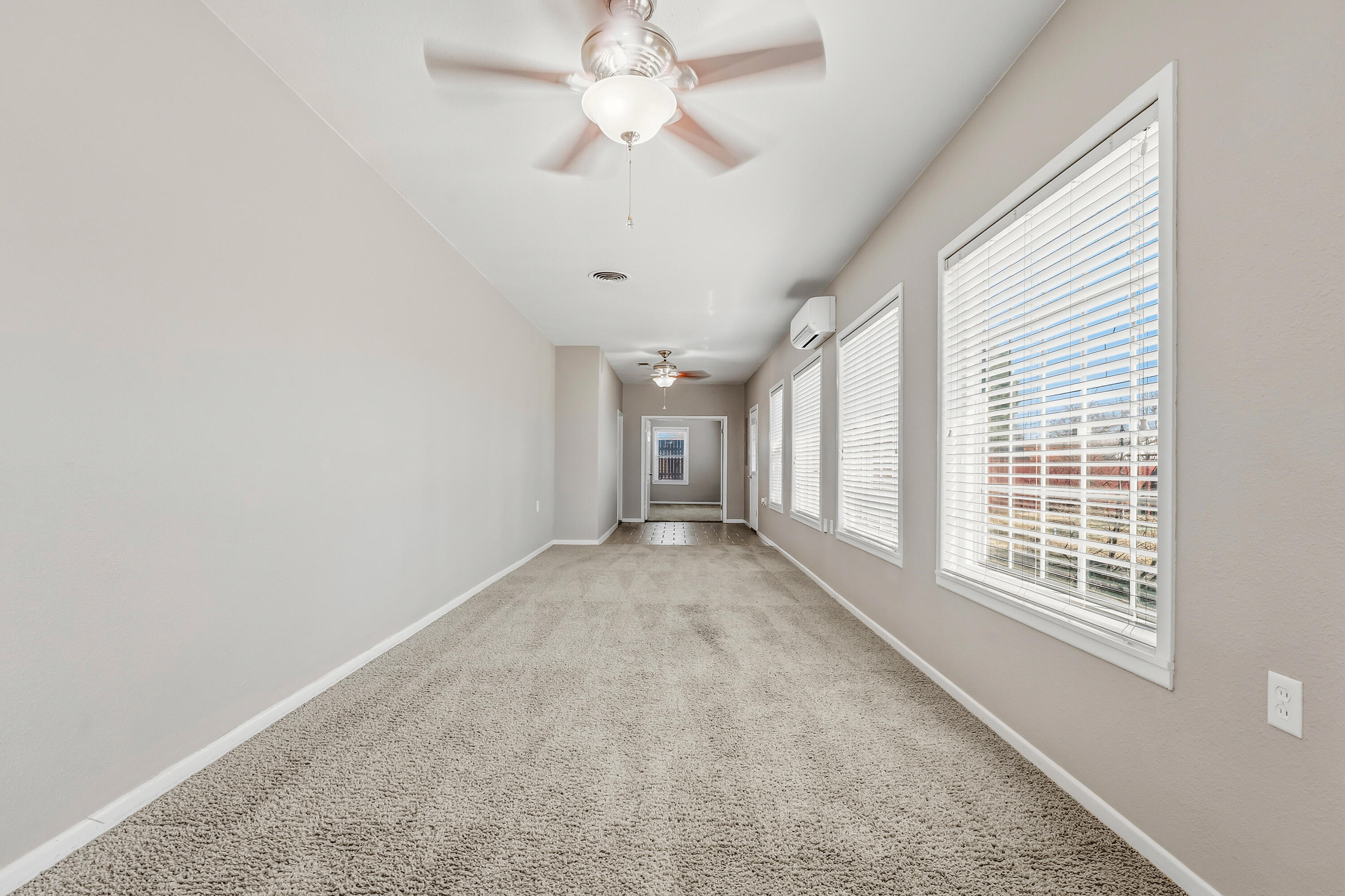 4831 10th Street Lubbock, TX 79416 - Photo 18 of 25 an empty room with chandelier fan and windows