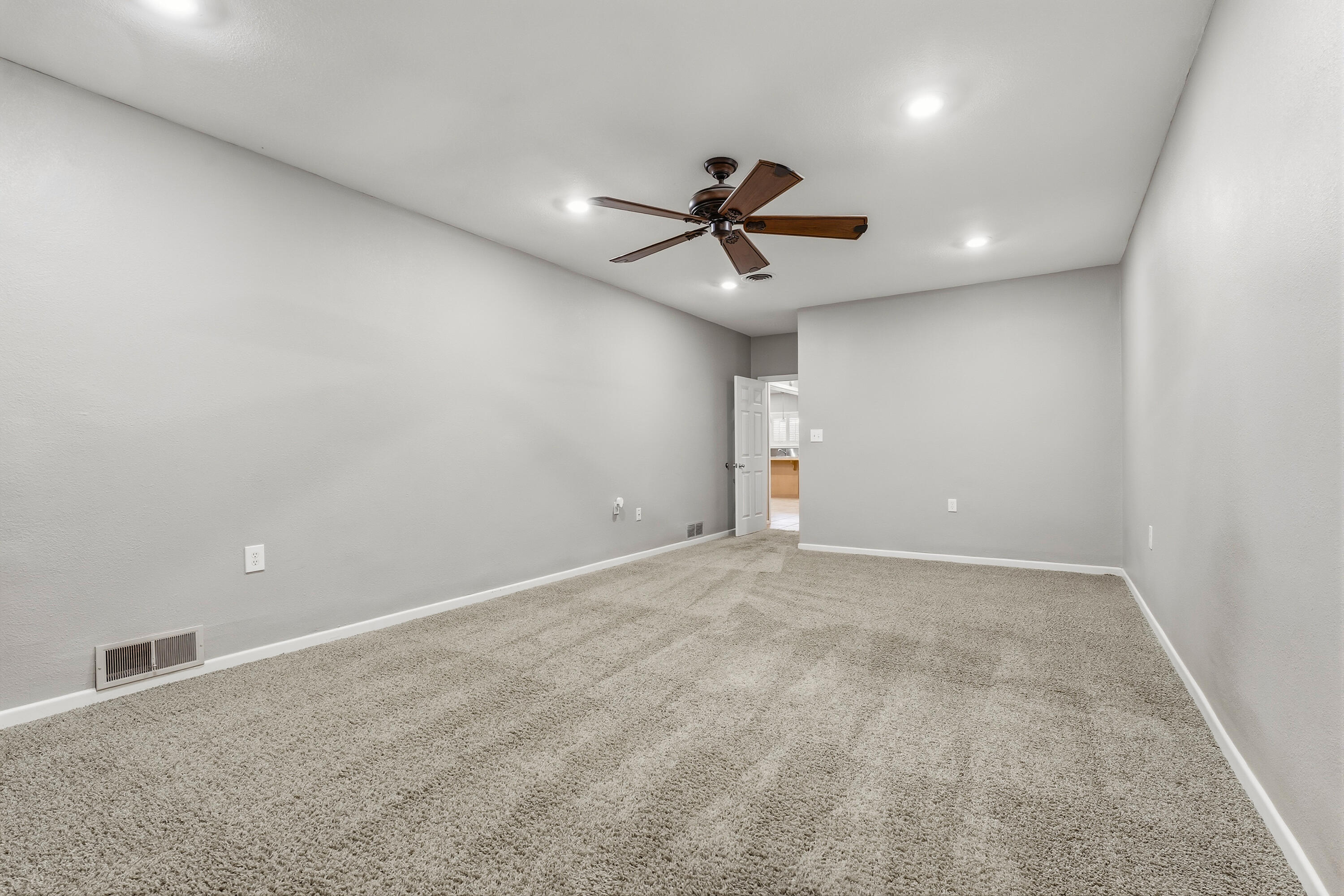 4831 10th Street Lubbock, TX 79416 - Photo 19 of 25 an empty room with a ceiling fan and a projector