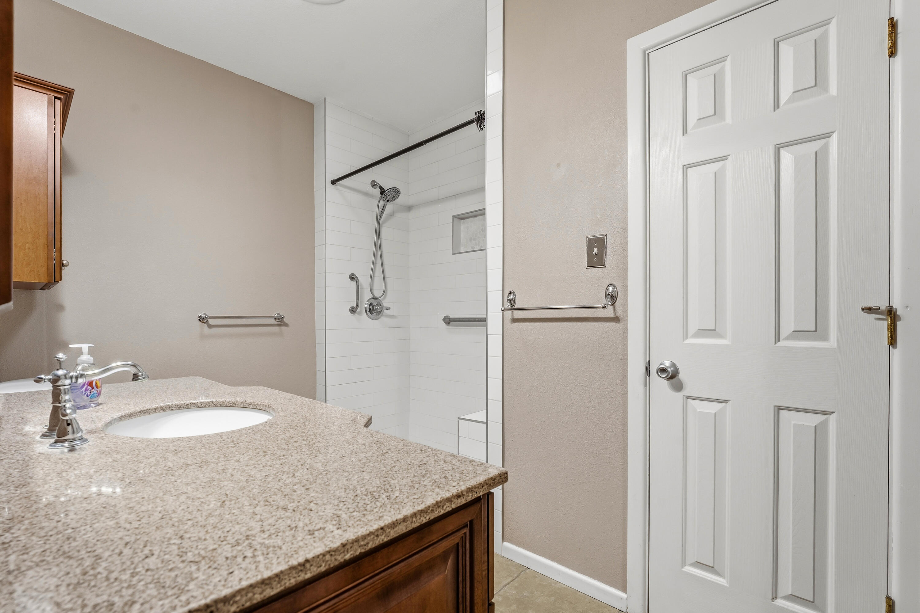 4831 10th Street Lubbock, TX 79416 - Photo 21 of 25 a bathroom with a granite countertop sink and mirror