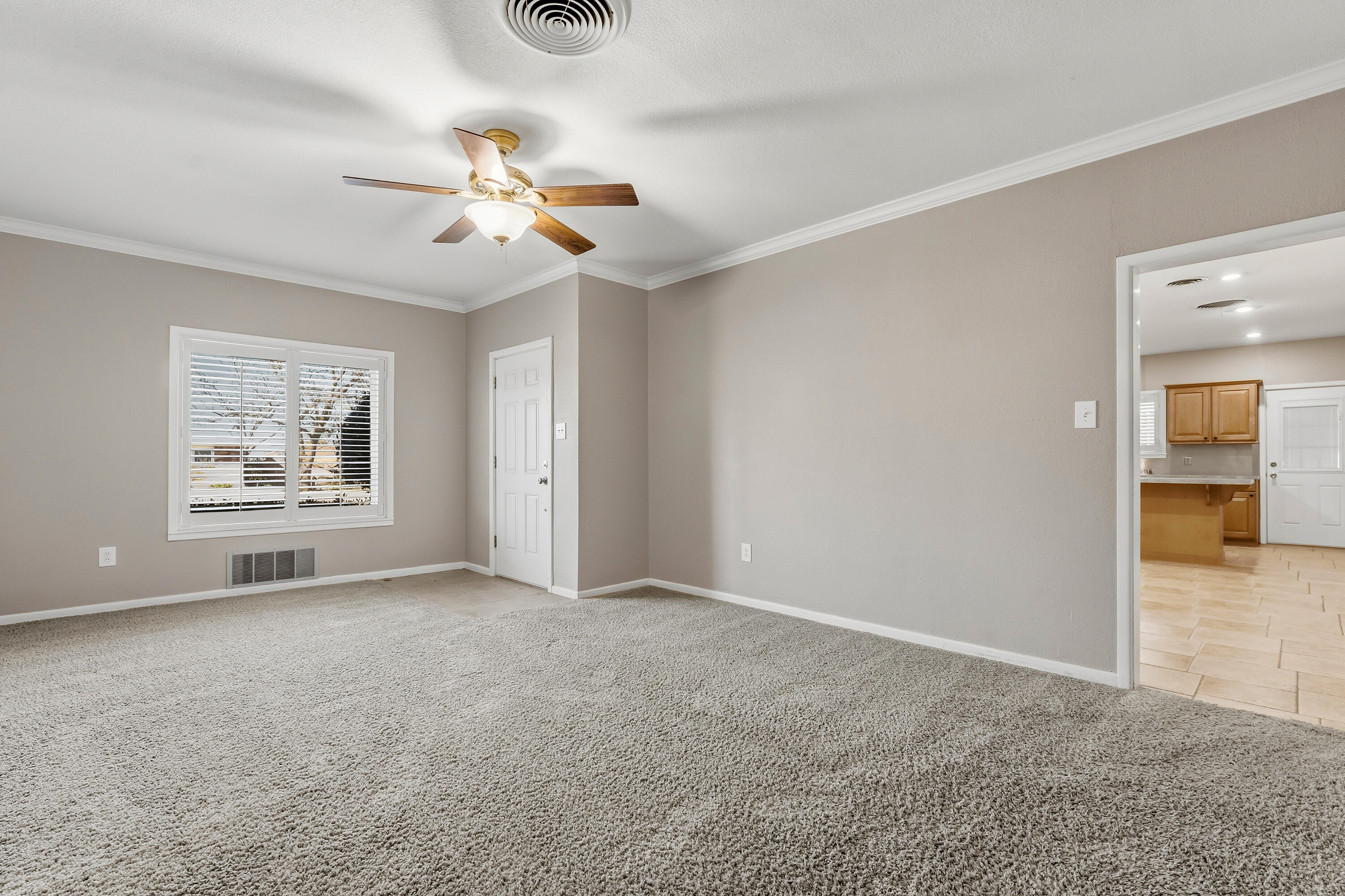 4831 10th Street Lubbock, TX 79416 - Photo 4 of 25 an empty room with windows and fan