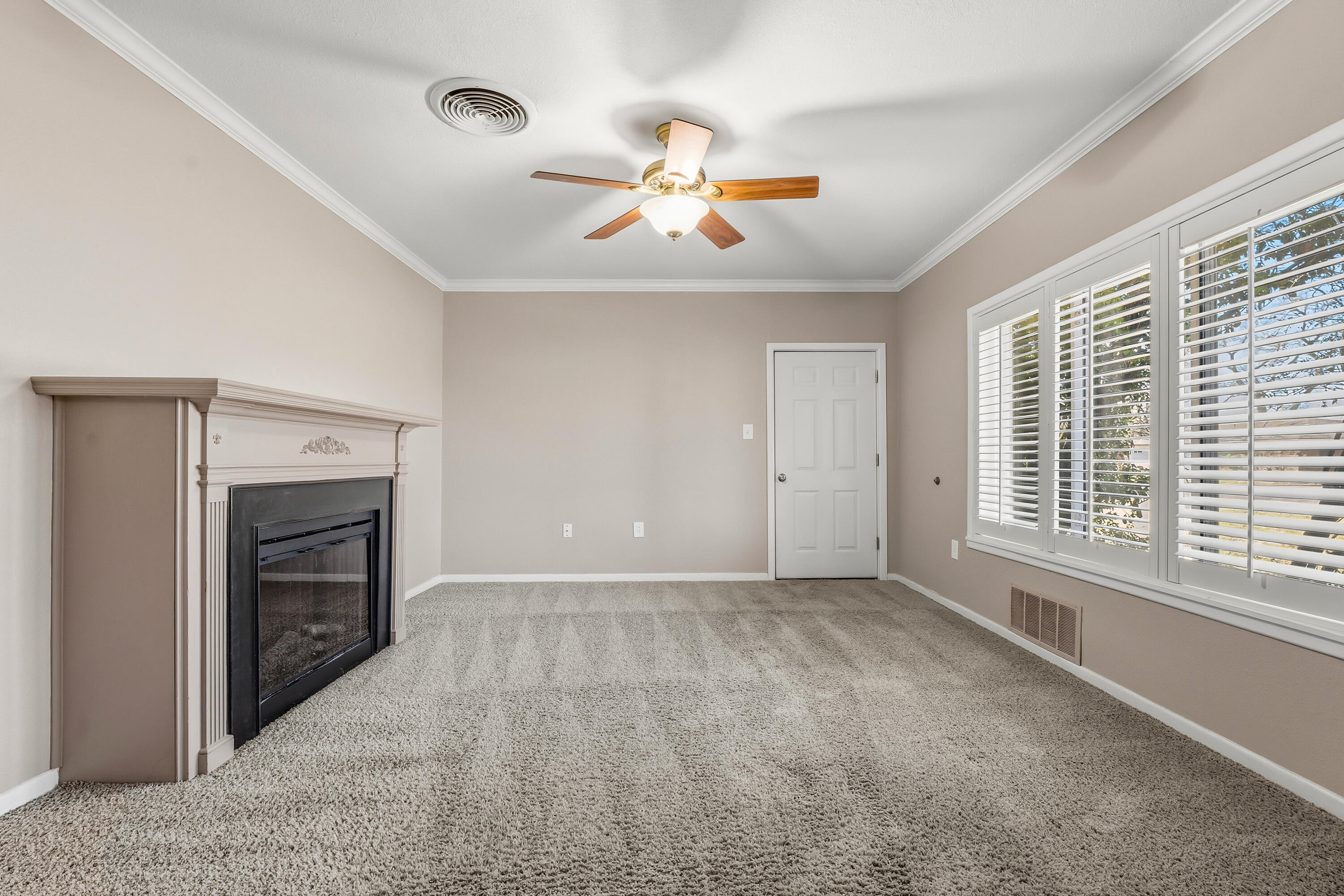 4831 10th Street Lubbock, TX 79416 - Photo 6 of 25 a view of an empty room with a fireplace and a window