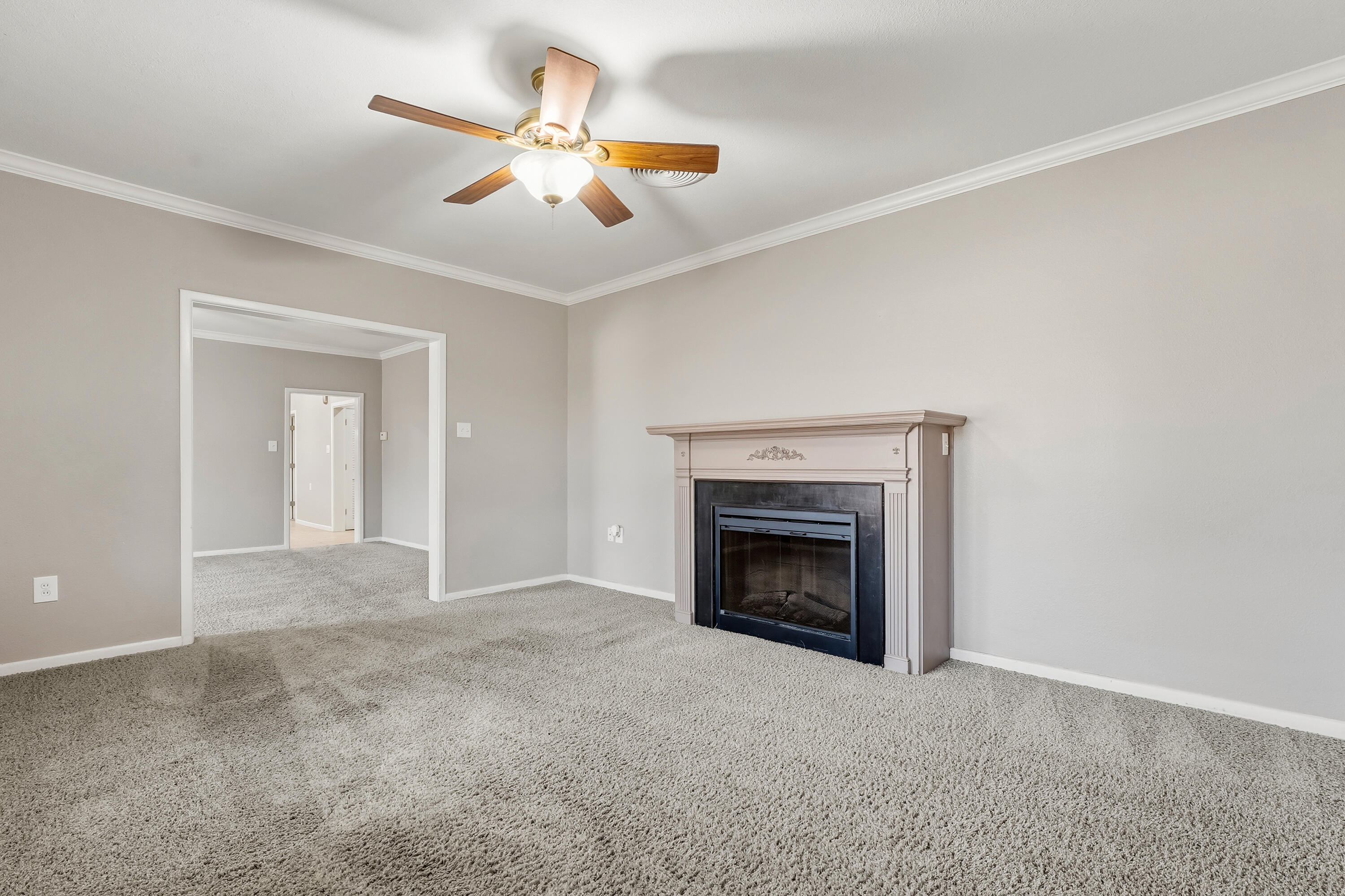 4831 10th Street Lubbock, TX 79416 - Photo 7 of 25 a view of an empty room with chandelier fan and fire place