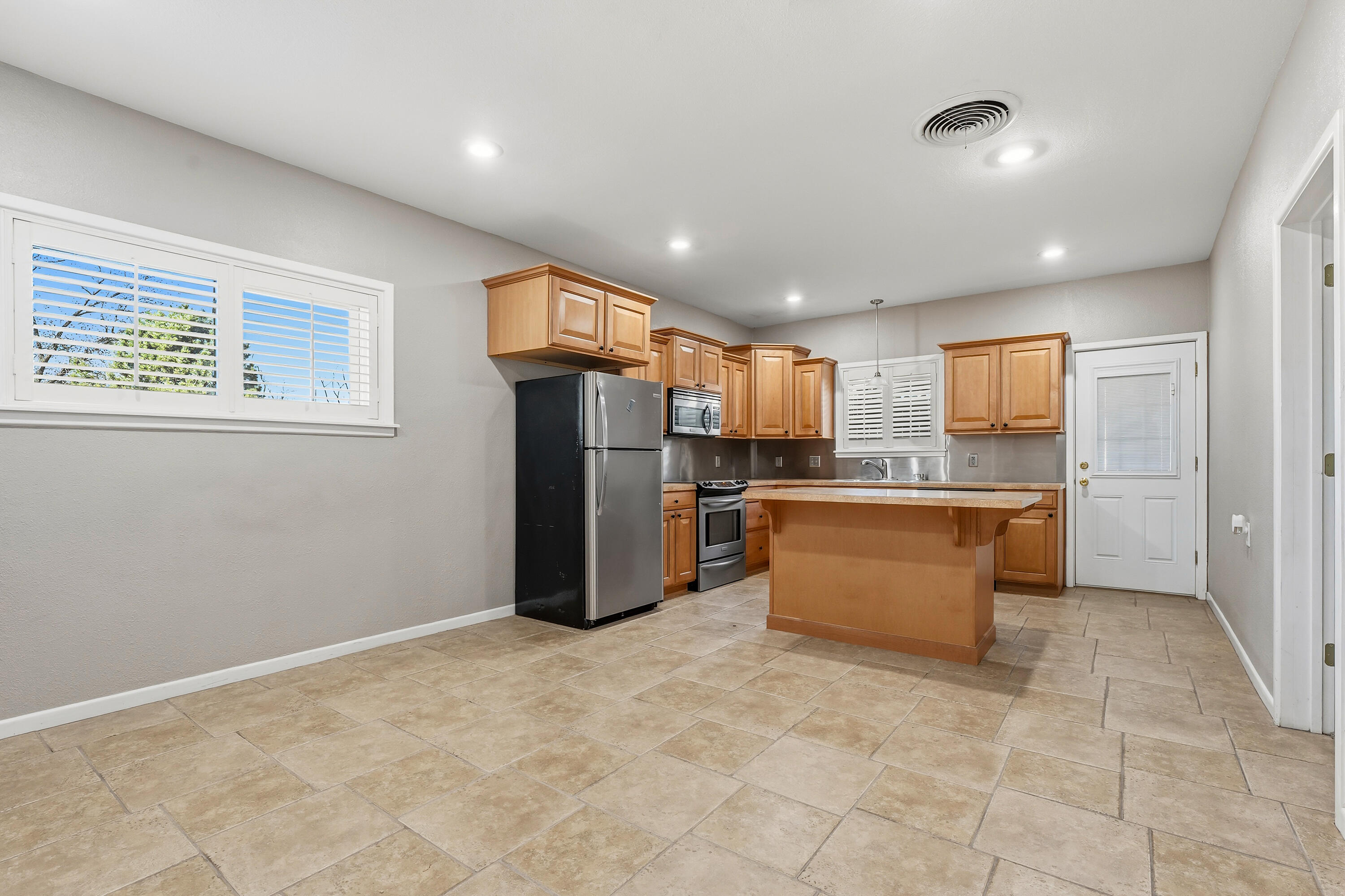 4831 10th Street Lubbock, TX 79416 - Photo 8 of 25 a large kitchen with stainless steel appliances granite countertop a refrigerator and a stove