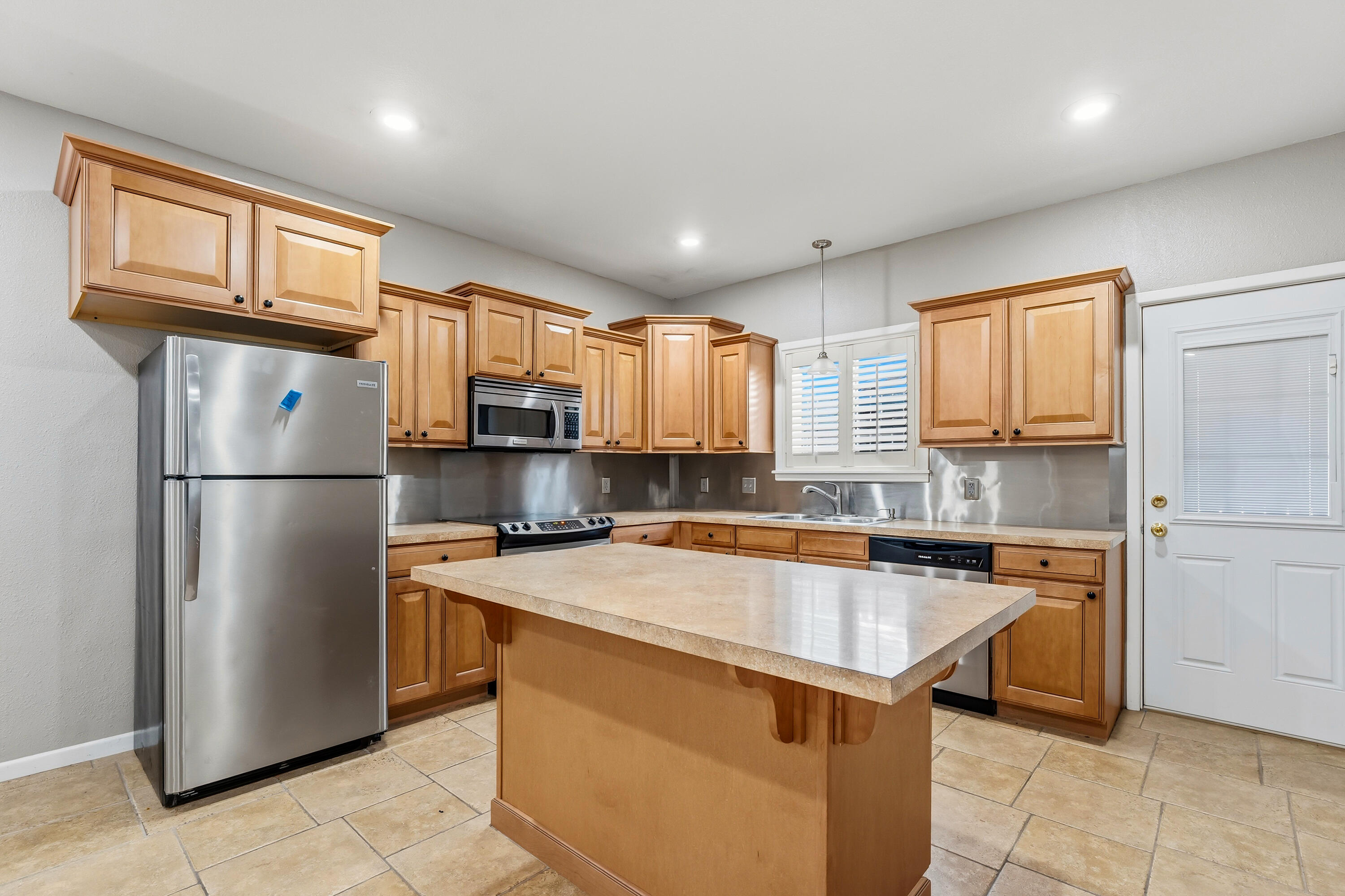 4831 10th Street Lubbock, TX 79416 - Photo 9 of 25 a kitchen with stainless steel appliances granite countertop a refrigerator a sink a stove a refrigerator and cabinets