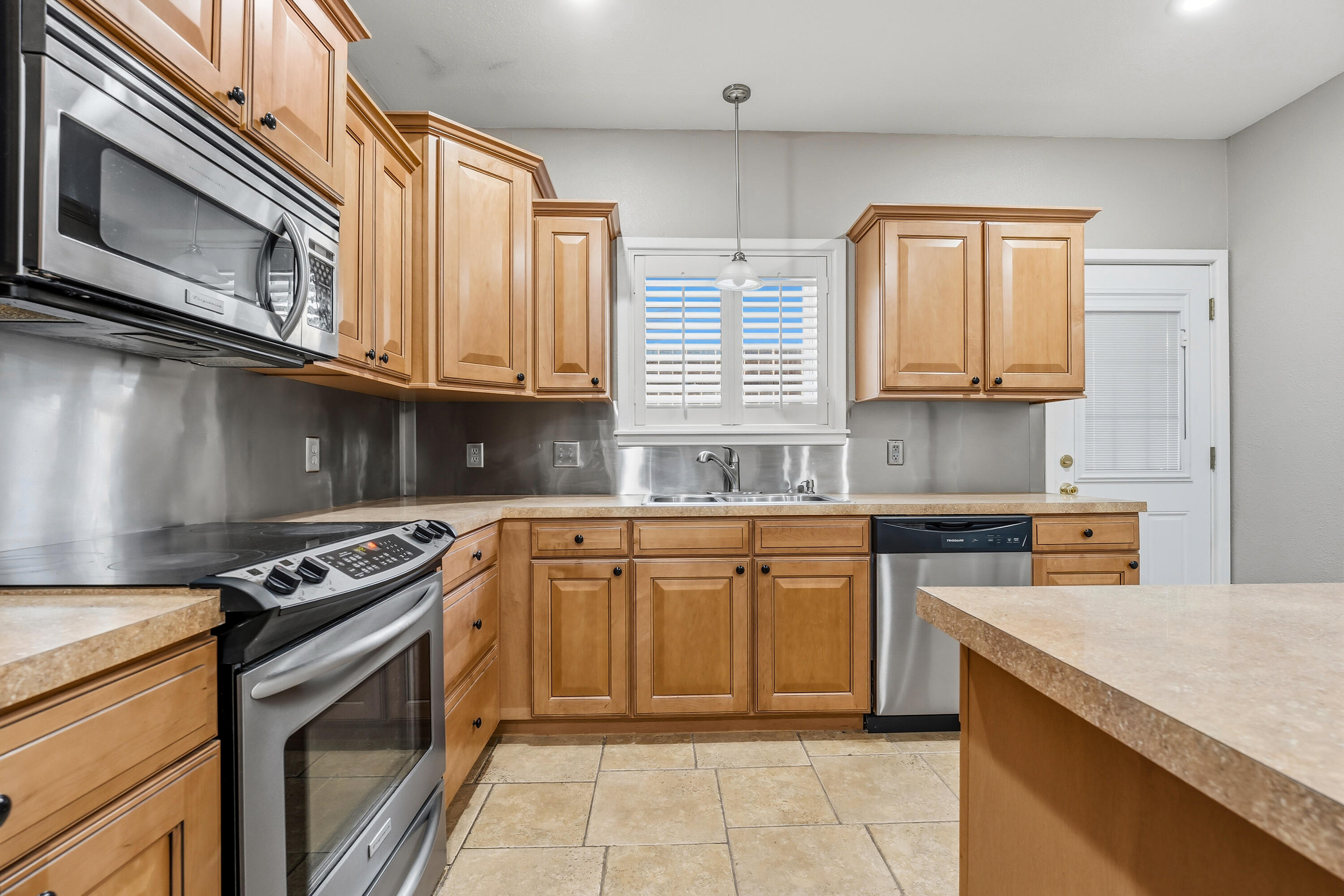 4831 10th Street Lubbock, TX 79416 - Photo 10 of 25 a kitchen with stainless steel appliances granite countertop a stove microwave and sink