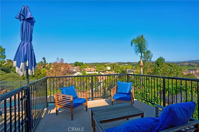 a patio with a table and chairs and potted plants