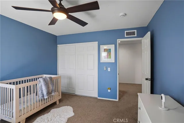 a bedroom with a bed and a lamp on dresser