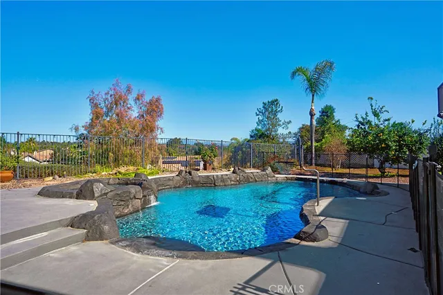 a view of a backyard with swimming pool and sitting area