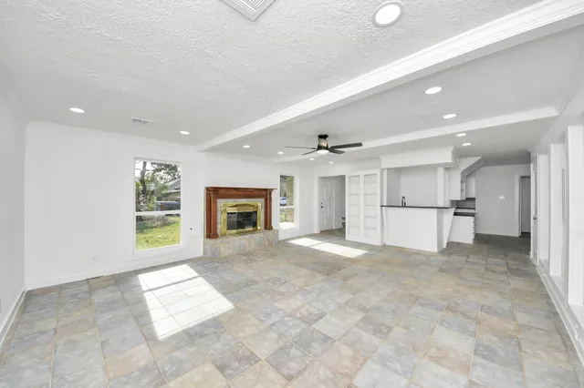 an empty room with a window and a fan