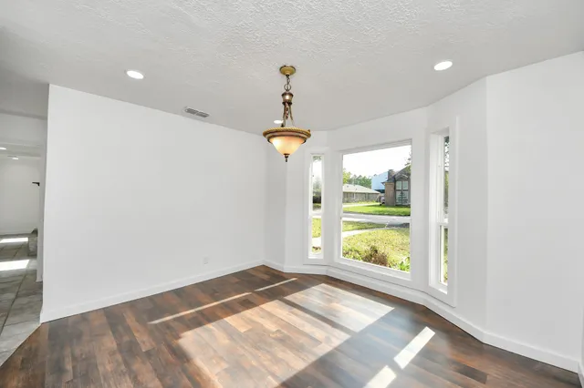 a kitchen with granite countertop white cabinets white appliances and a sink