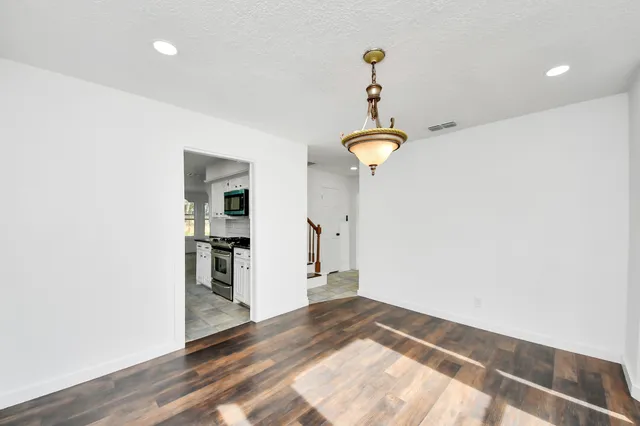 a kitchen with granite countertop white cabinets white stainless steel appliances and a sink