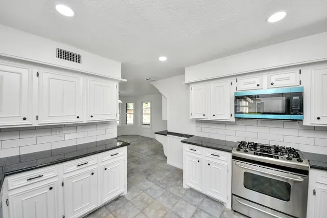 a view of an empty room with a fireplace and a window