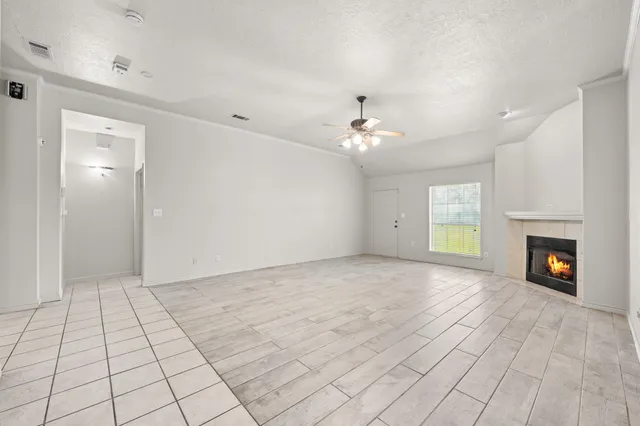 a view of an empty room with a chandelier fan