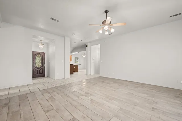 an empty room with windows and fireplace
