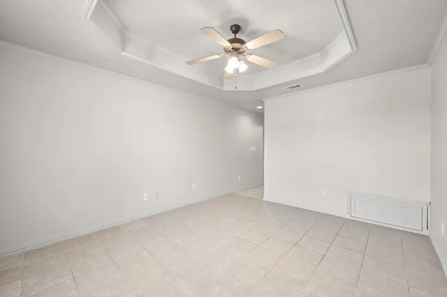 an empty room with a window and a ceiling fan