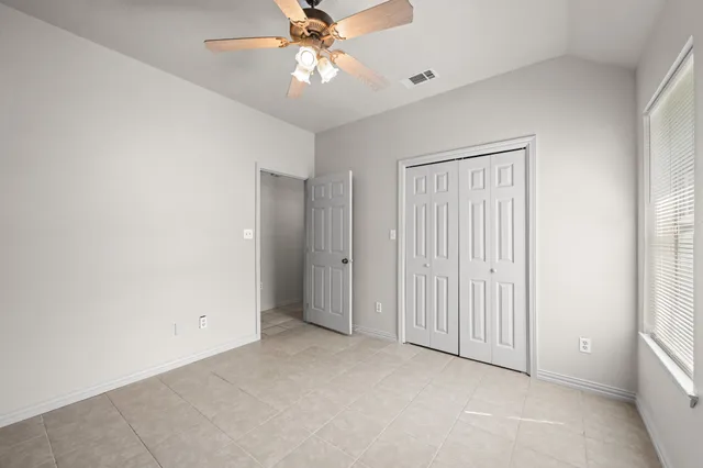 an empty room with fan and windows