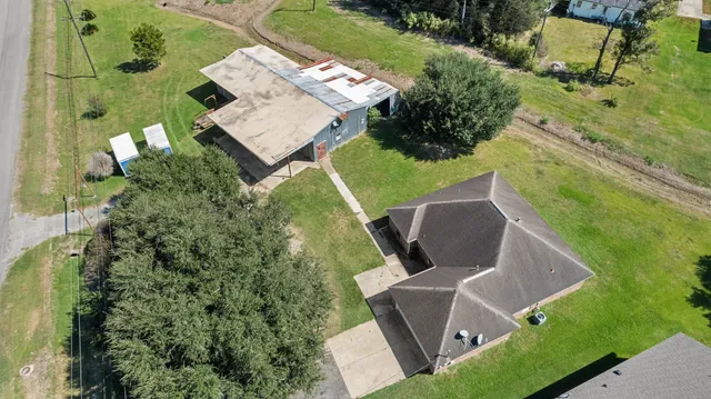 an aerial view of ocean and residential houses with outdoor space