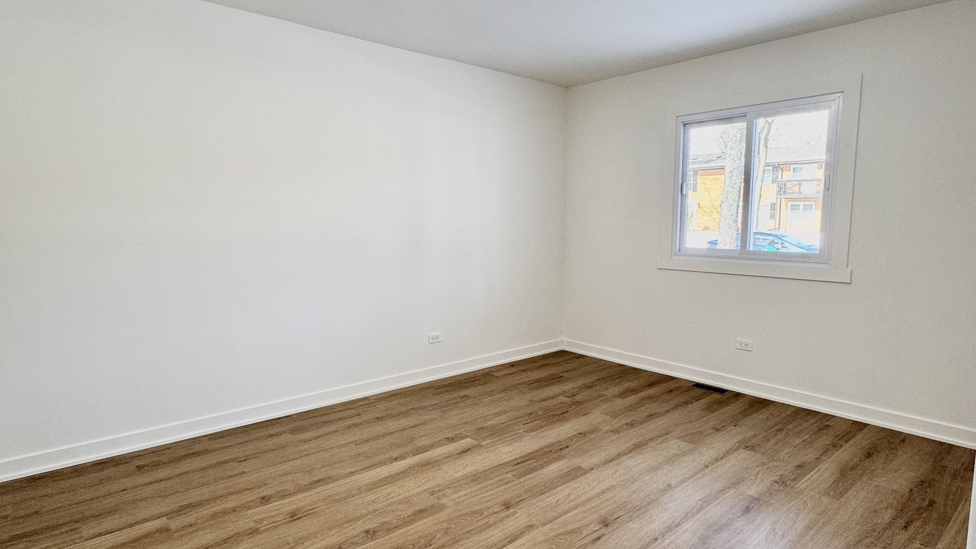 633 Dulles Road, Unit A Des Plaines, IL 60016 - Photo 16 of 26 an empty room with wooden floor and windows