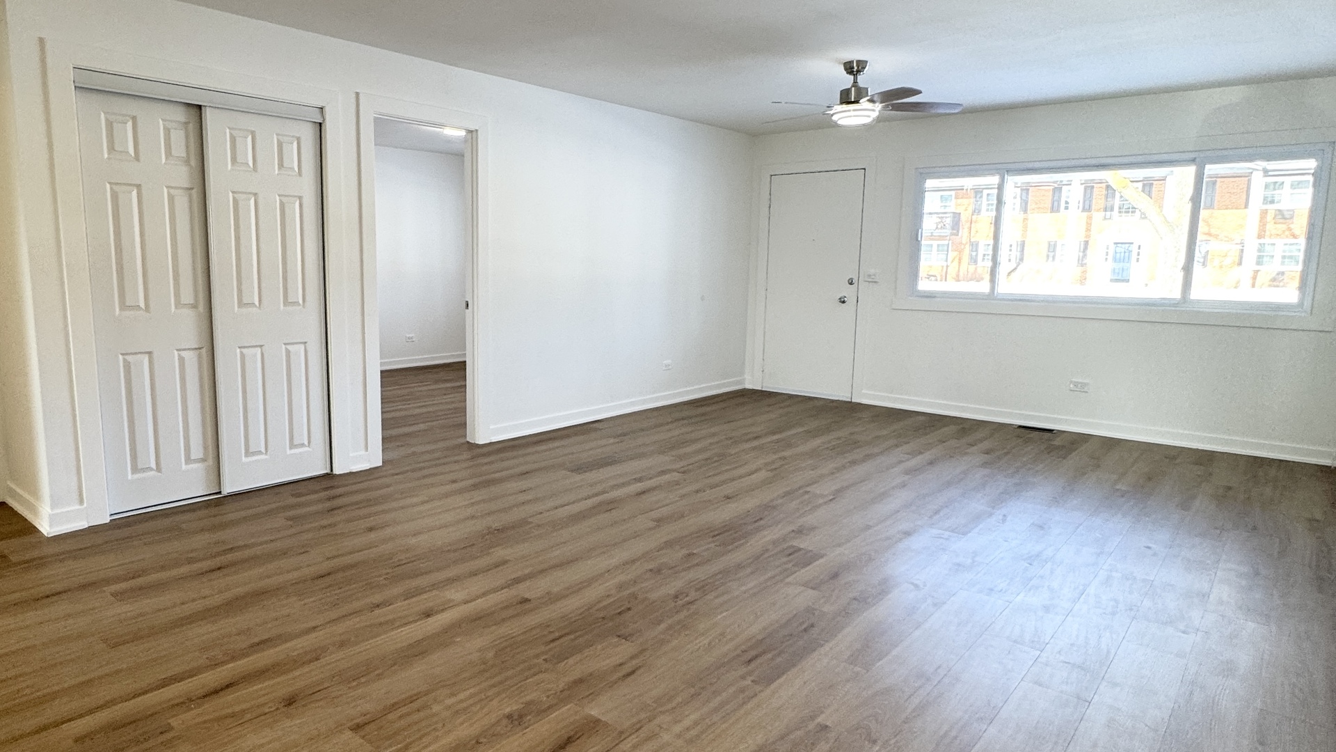 633 Dulles Road, Unit A Des Plaines, IL 60016 - Photo 6 of 26 a view of an empty room with wooden floor and a window
