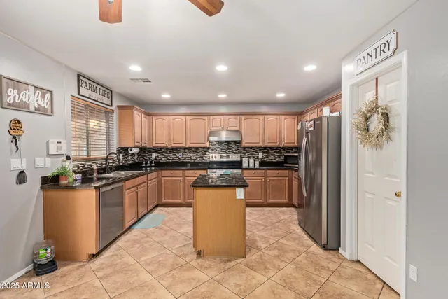 a kitchen with a refrigerator and a stove top oven