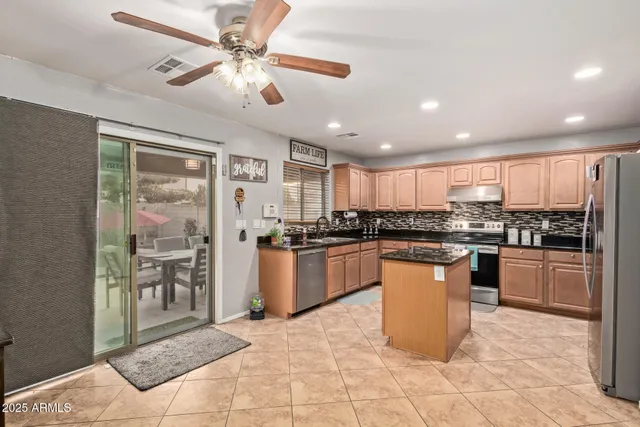 a kitchen with stainless steel appliances granite countertop a sink a stove a counter space and cabinets