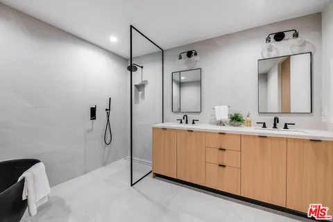 a bathroom with a double vanity sink mirror and shower