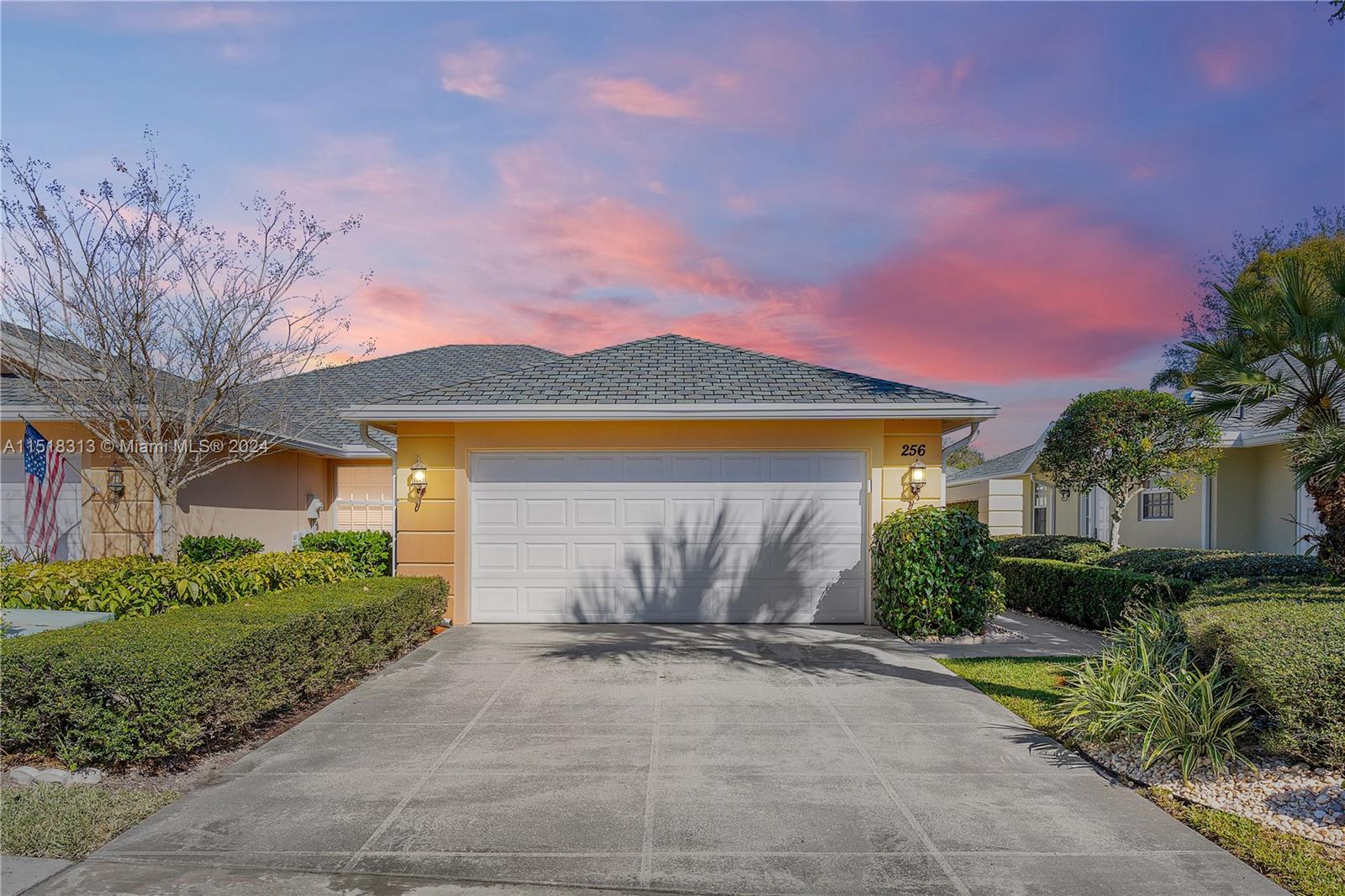 a view of a house with a yard and potted plants