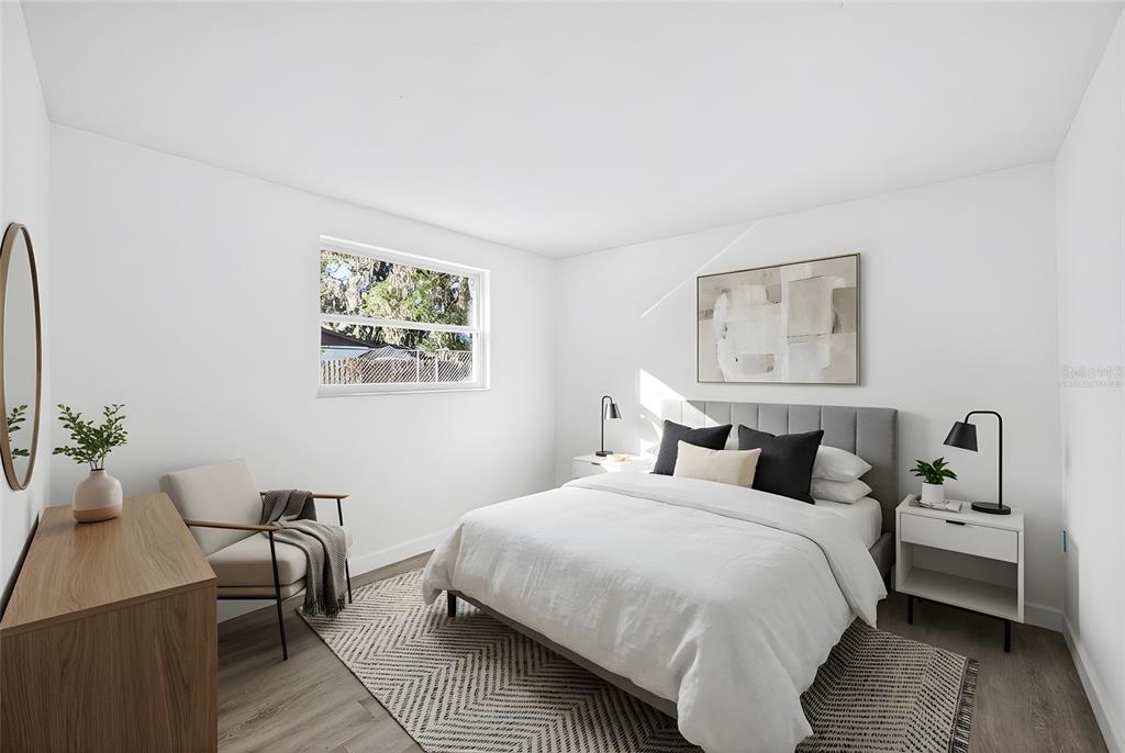 4928 Amherst Court New Port Richey, FL 34652 - Photo 16 of 50 a bedroom with a bed and wooden floor