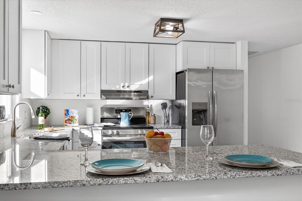 4928 Amherst Court New Port Richey, FL 34652 - Photo 2 of 50 a kitchen with a refrigerator a stove and cabinets