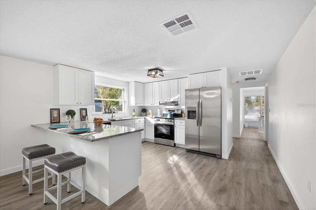 4928 Amherst Court New Port Richey, FL 34652 - Photo 3 of 50 a kitchen with refrigerator cabinets and wooden floor