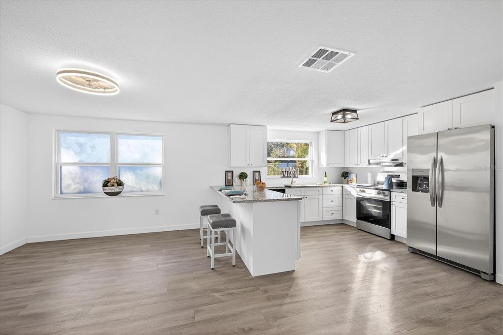 4928 Amherst Court New Port Richey, FL 34652 - Photo 33 of 50 a kitchen with white cabinets and stainless steel appliances