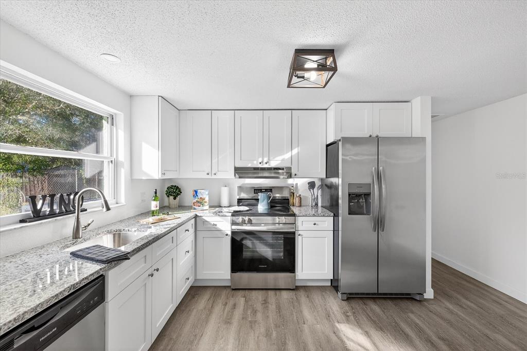 4928 Amherst Court New Port Richey, FL 34652 - Photo 36 of 50 a kitchen with a refrigerator a sink stainless steel appliances and cabinets