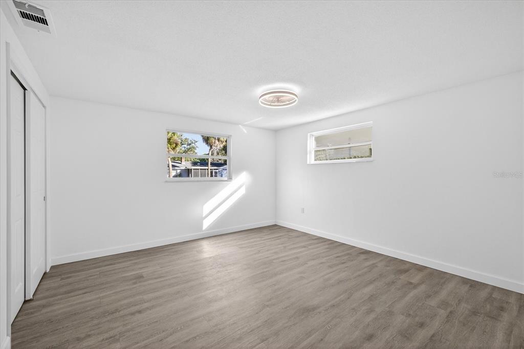 4928 Amherst Court New Port Richey, FL 34652 - Photo 42 of 50 an empty room with wooden floor and windows