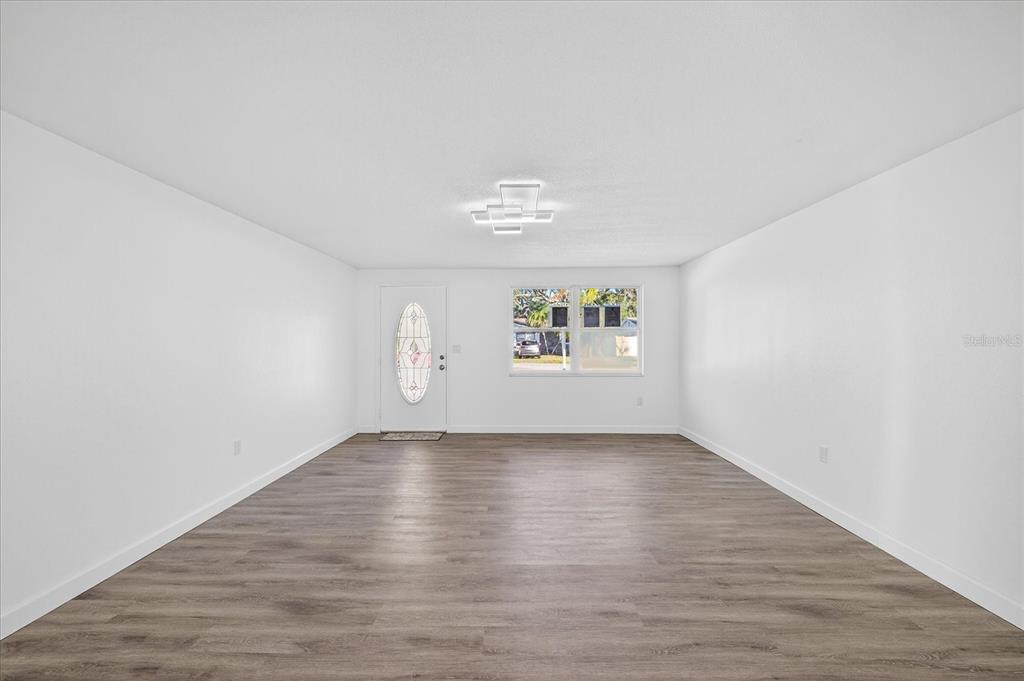 4928 Amherst Court New Port Richey, FL 34652 - Photo 7 of 50 an empty room with wooden floor and windows