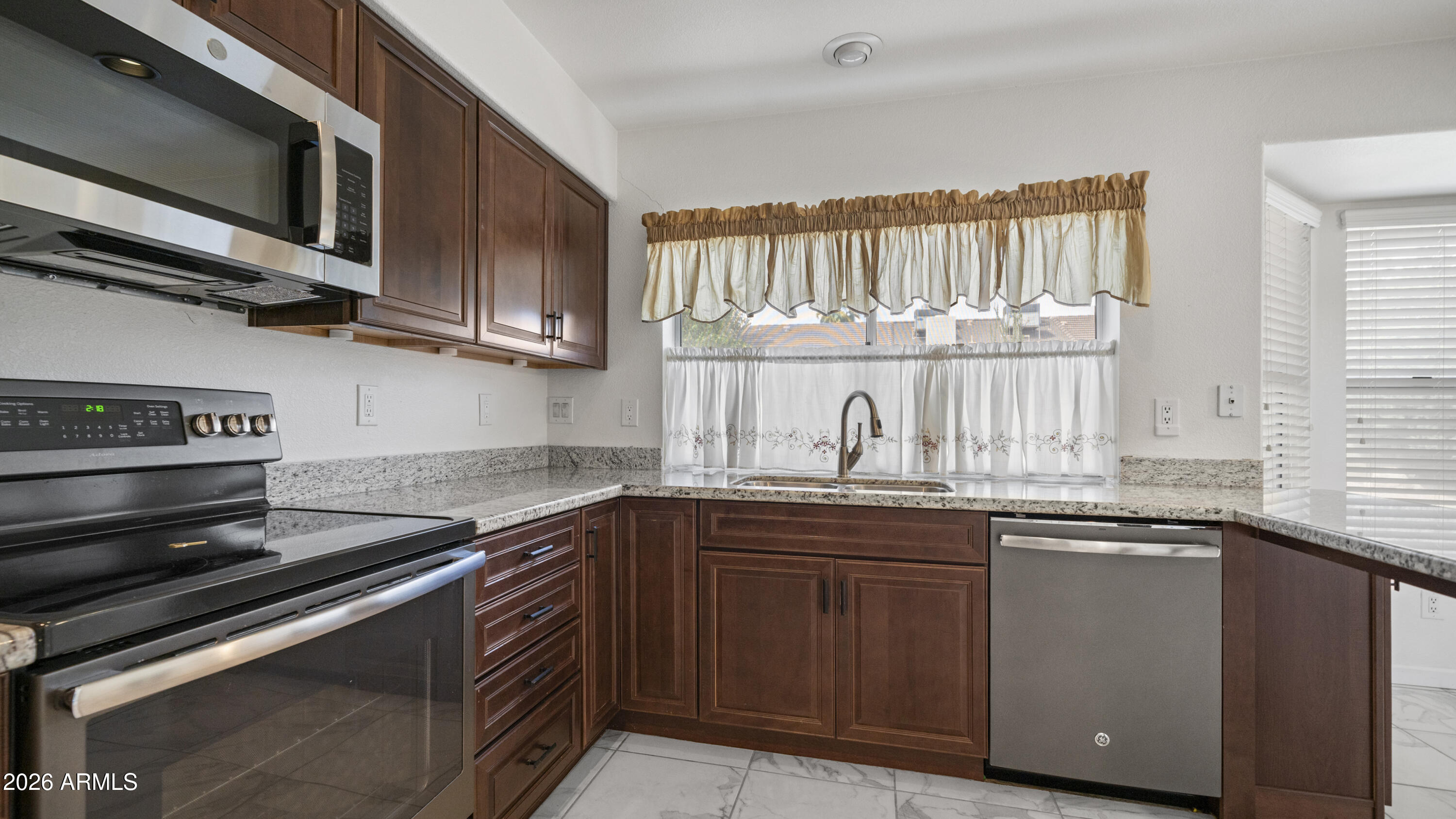 6620 West Redfield Road Glendale, AZ 85306 - Photo 7 of 33 a kitchen with stainless steel appliances granite countertop a sink and a stove