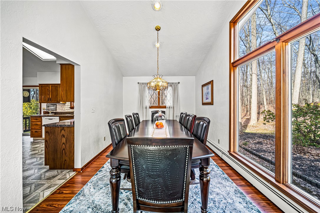 1305 Garrison Road Ashtabula, OH 44004 - Photo 13 of 46 Dining room with dark hardwood / wood-style floors, a skylight, a baseboard radiator, and a chandelier