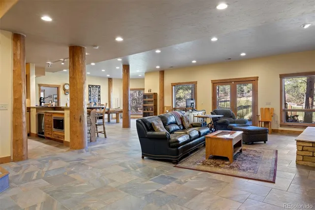 a living room with furniture kitchen view and a large window
