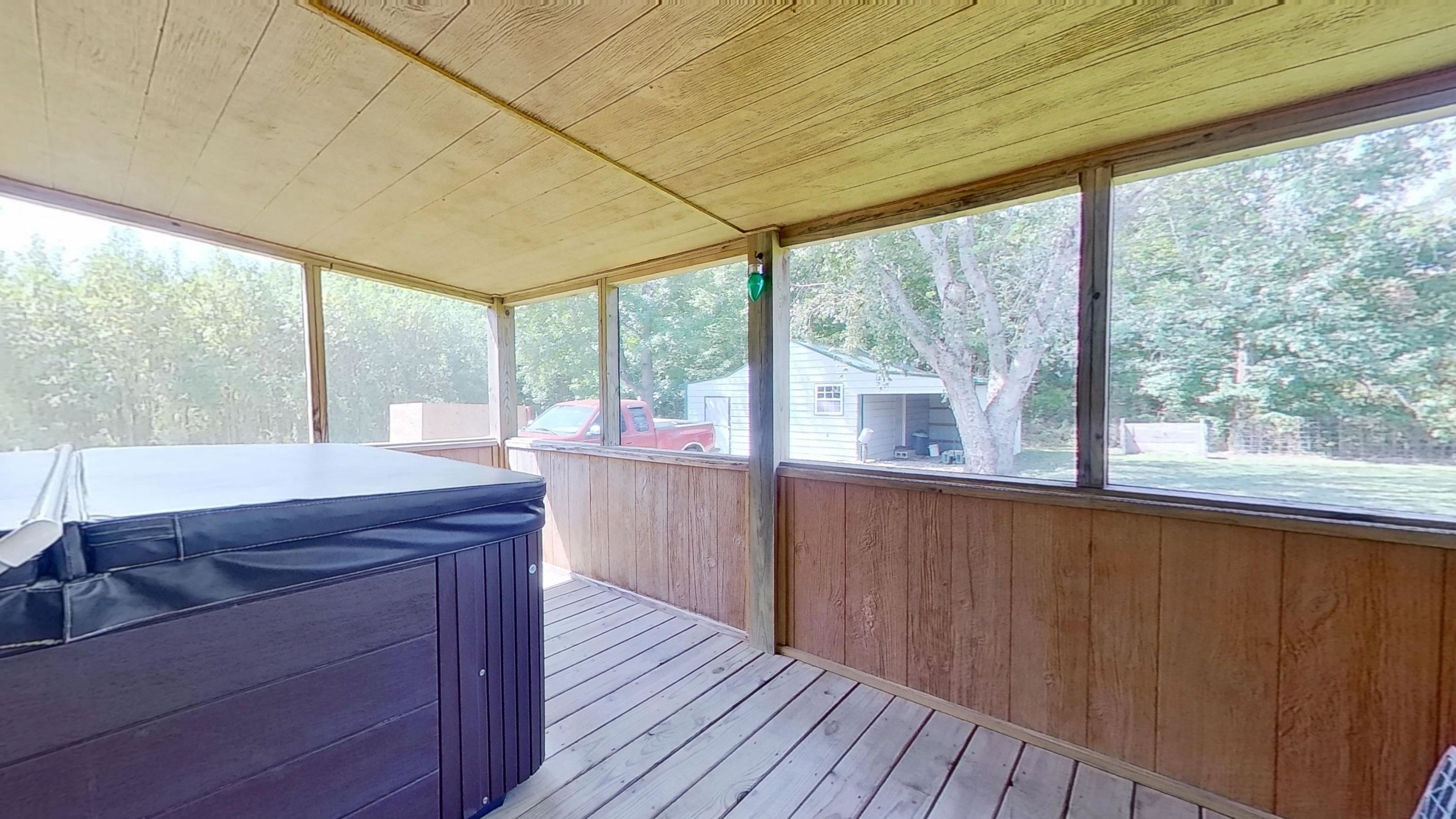 30 Rodeo Way Savannah, TN 38372 - Photo 21 of 29 Deck with a sunroom, a hot tub, and view of wooded area