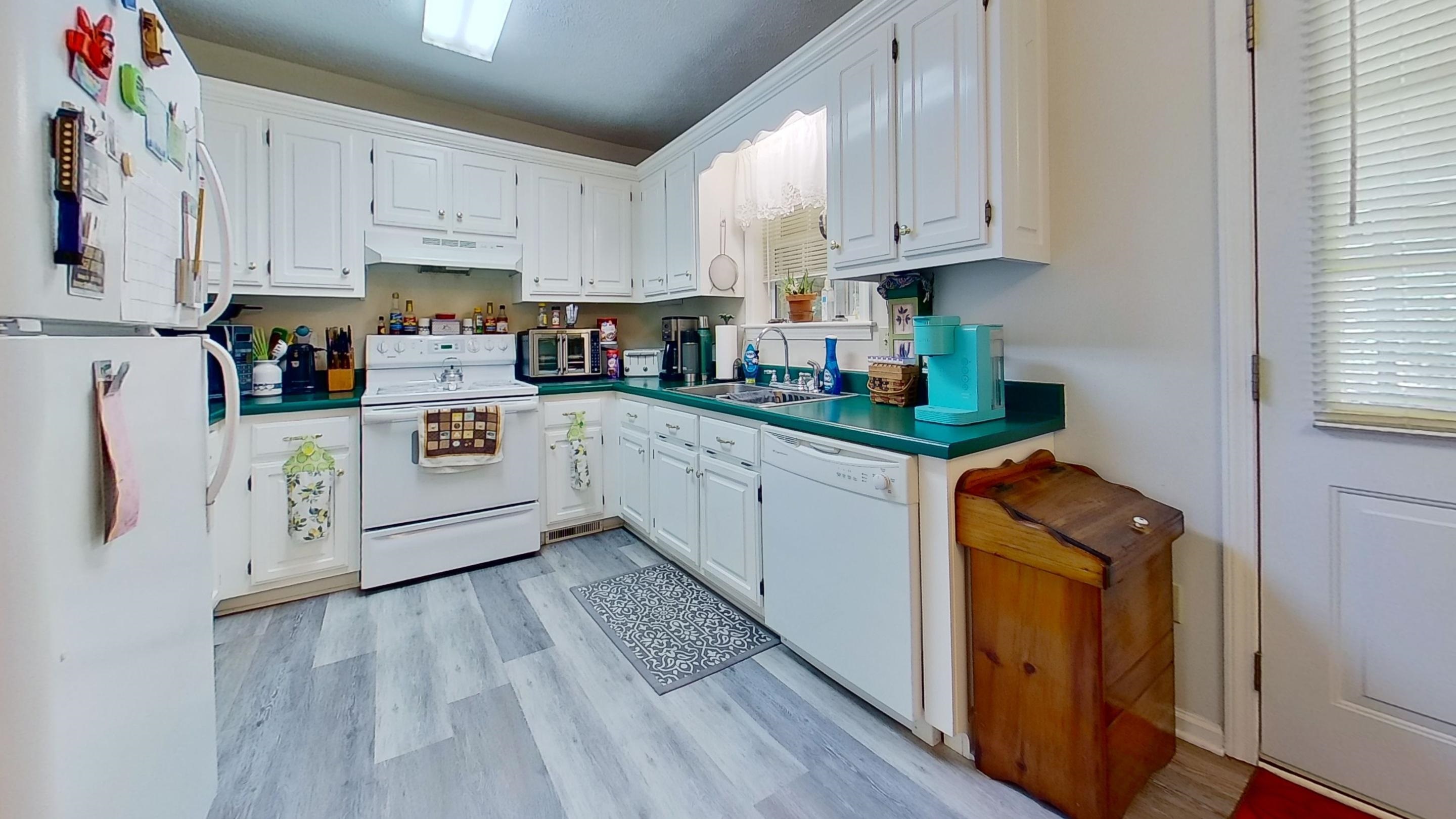 30 Rodeo Way Savannah, TN 38372 - Photo 4 of 29 Kitchen featuring white appliances, white cabinetry, under cabinet range hood, and light wood finished floors
