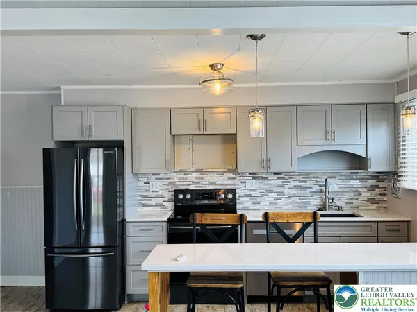 a kitchen with stainless steel appliances granite countertop a refrigerator a stove a sink and a refrigerator