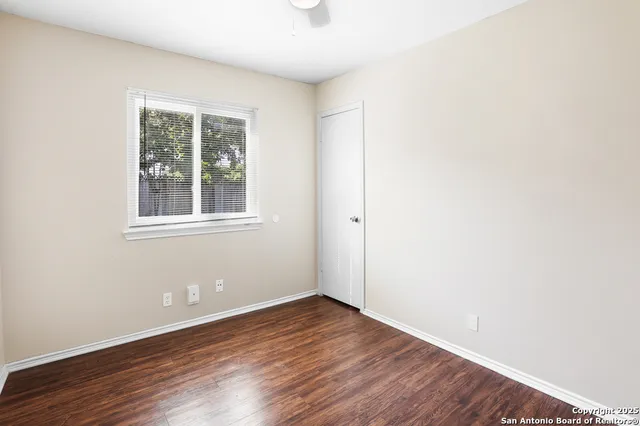 a view of an empty room with wooden floor
